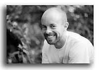 Black and white portrait of Daniel smiling at the camera